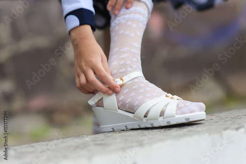 little girl putting on her sandals