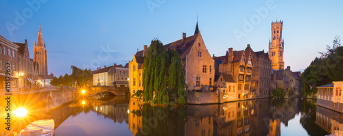 Panorama of Bruges, Belgium. Image with Rozenhoedkaai in Brugge, Dijver river canal and Belfort, Belfry, tower in twilight. photo