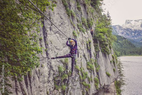 Woman walking on the rope in via ferrata, Gosausee, Austria