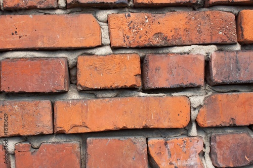 Old wall from red brick. Red clay brick. Brick wall. The old crumbling brick wall. Bricks and stones in the old wall. The old brick wall collapses and urgent repair is necessary. 