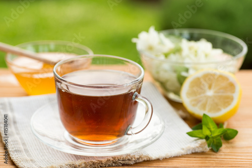 Herbal tea in a cup with and honey, summer garden