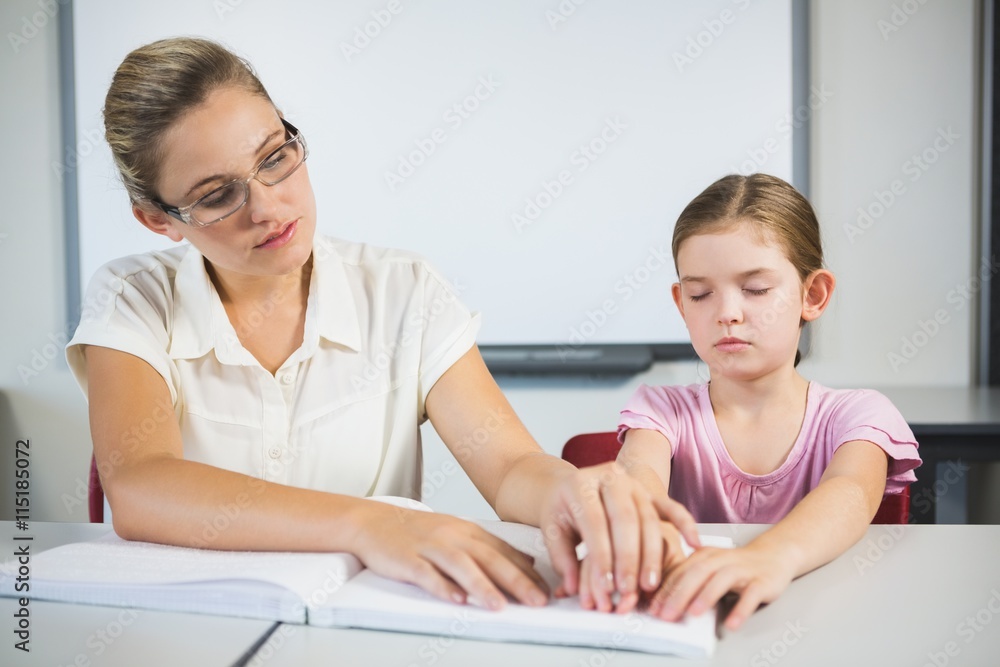 Teacher assisting blind student in library Teacher assisting blind student in library