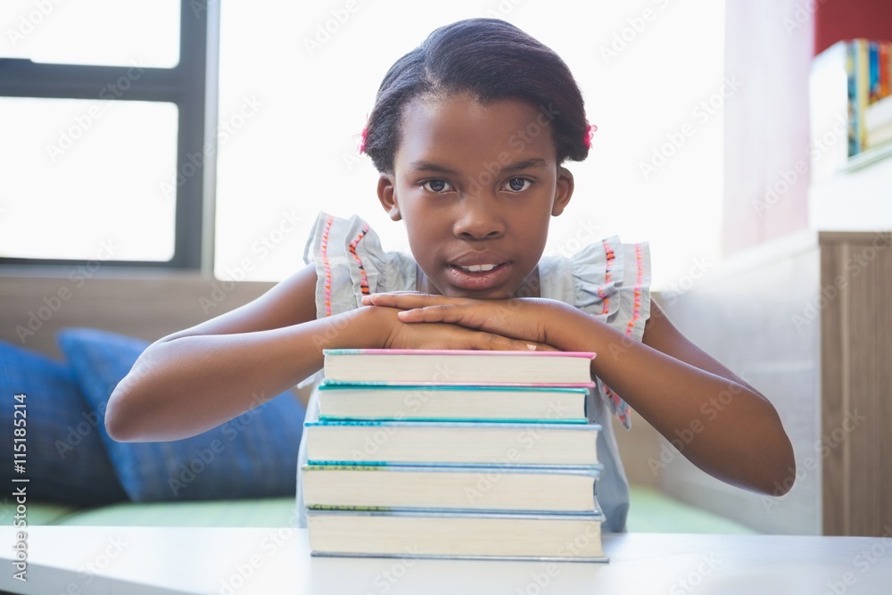 Portrait of smiling girl leaning on stack of books in class room Portrait of smiling girl leaning on stack of books in class room