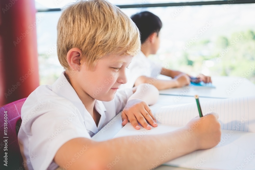 Schoolkid doing homework in classroom Schoolkid doing homework in classroom