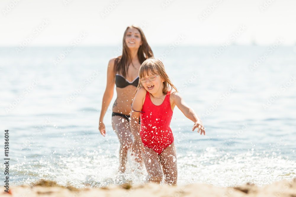 Little girl kid and woman mother in sea water. Fun