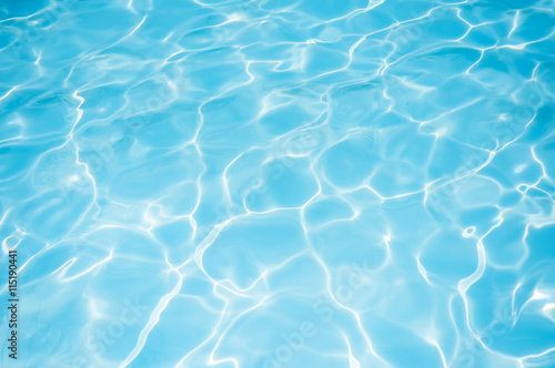 Ripple blue water surface with sun reflection in swimming pool