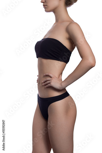 Slim body of the suntanned woman isolated on a white background. Black underwear. hands on waist. Healthy lifestyle, Diets.