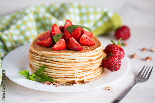 Delicious pancakes with strawberry on wooden background