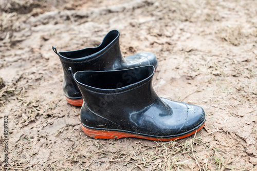 black plastic boot on the wet sludge wet mud 
