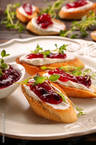 Toast with white cottage cheese cherry jam and fresh herbs