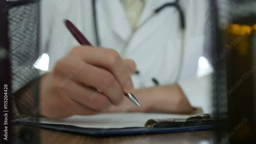 Doctor writing prescription in hospital Doctor writing prescription in hospital