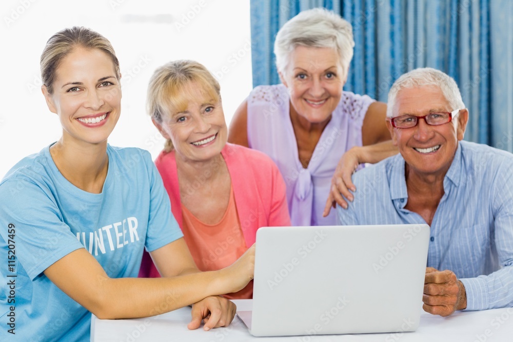Volunteer and seniors using a laptop Volunteer and seniors using a laptop