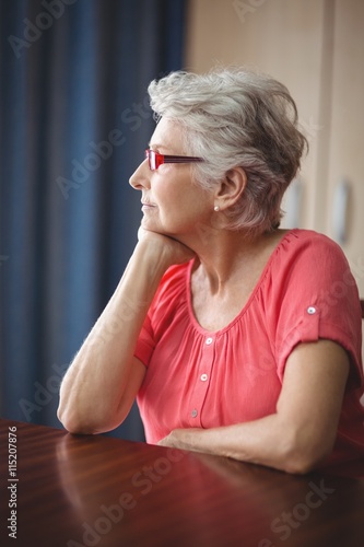 Thoughtful senior woman sitting at a table