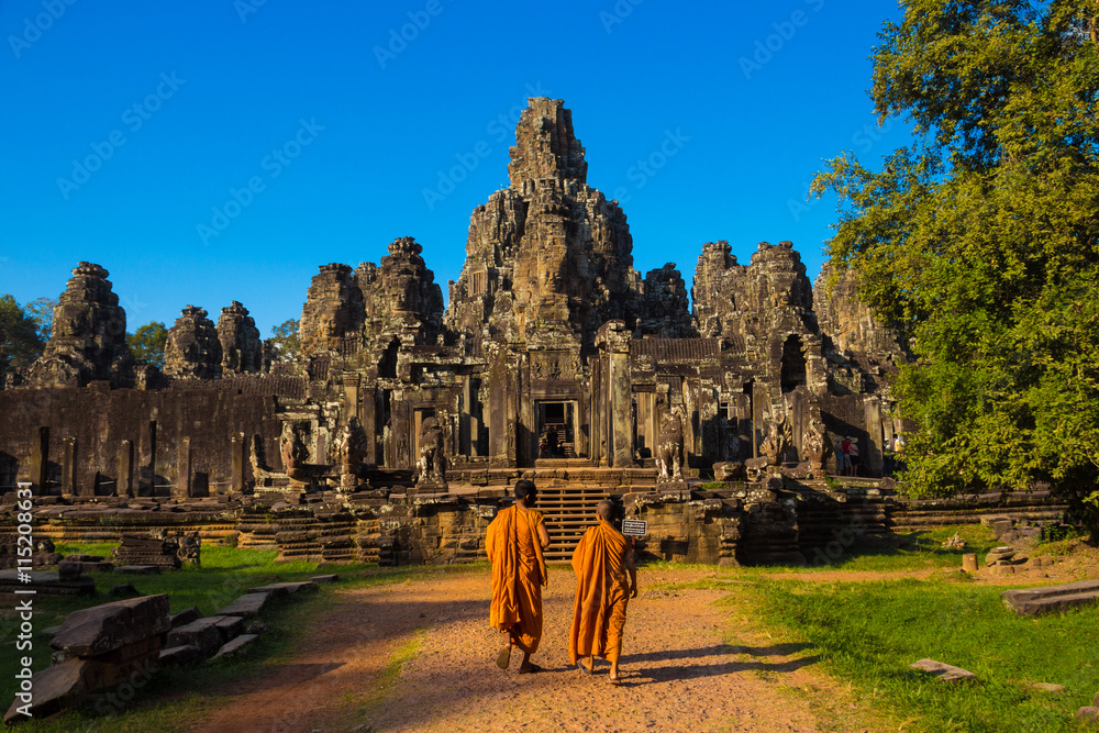 Naklejka premium The monks in the ancient stone faces of Bayon temple