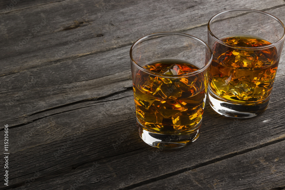 Whisky in two glasses on a dark wooden background