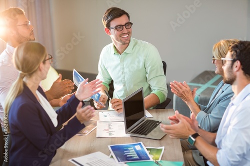 Coworkers applauding a colleague after presentation