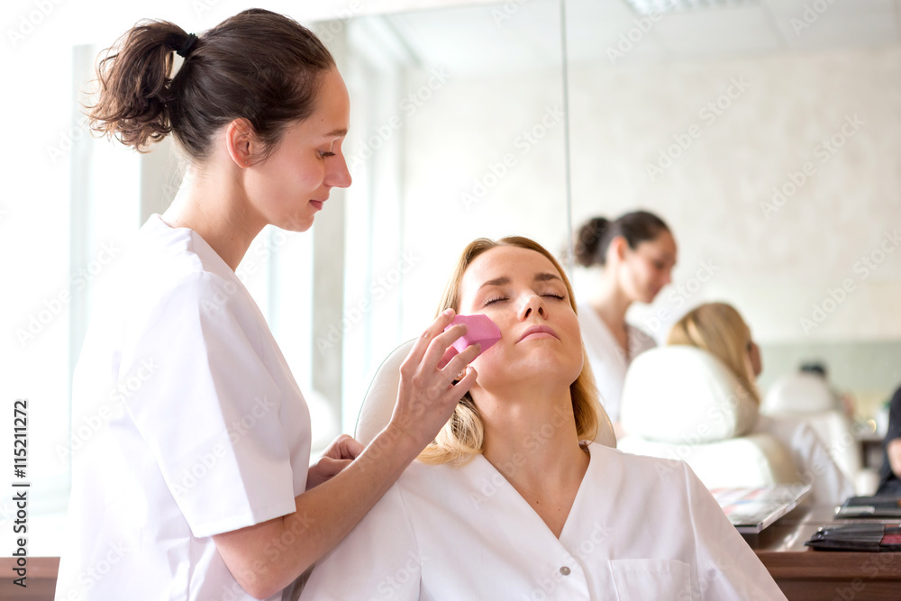 Two young beautician students working during make up classes Two young beautician students working during make up classes