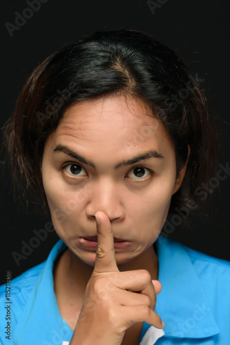 Woman holding finger to lips. photo