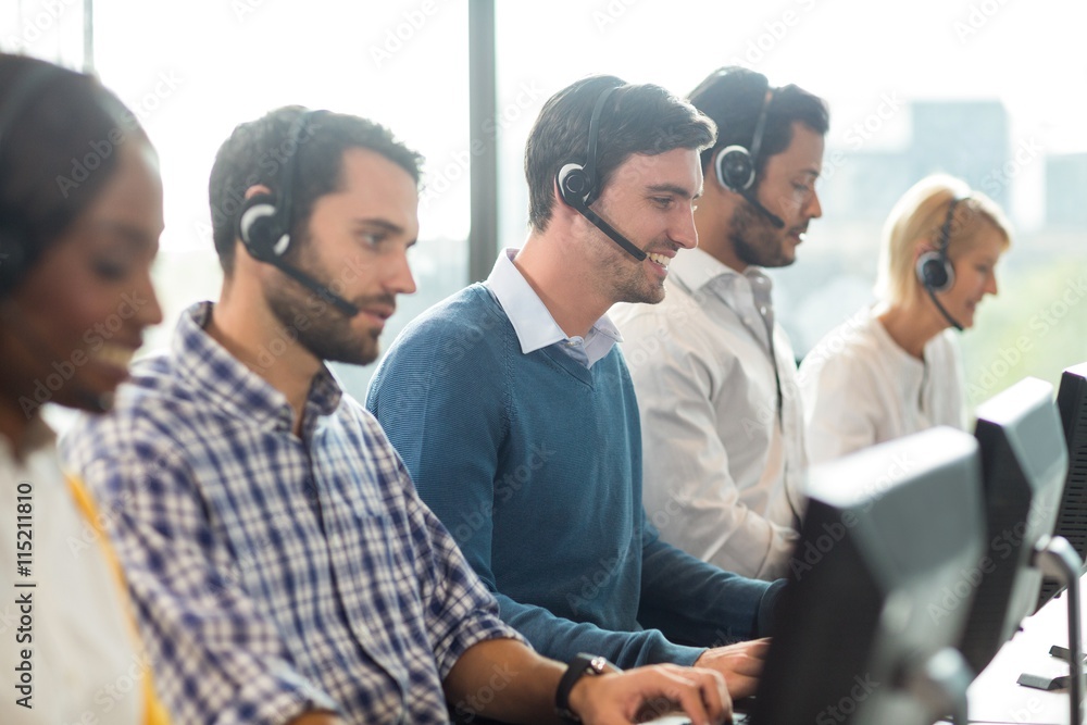 Team of colleagues working at their desk with headset Team of colleagues working at their desk with headset