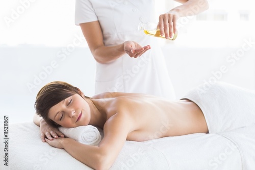 Midsection of masseur giving massage to woman
