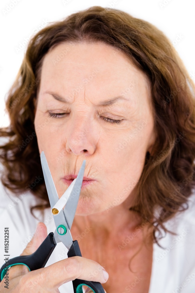 Mature woman cutting cigarette with scissors Mature woman cutting cigarette with scissors