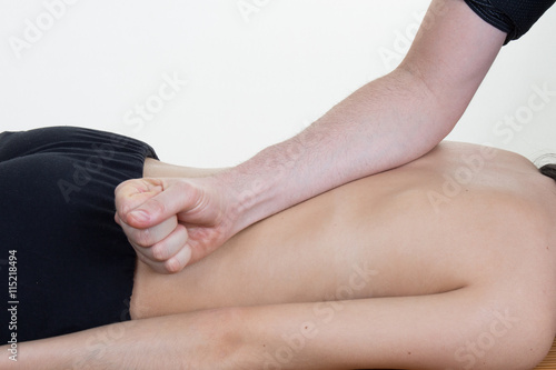Doctor massaging the back of his patient while using the back