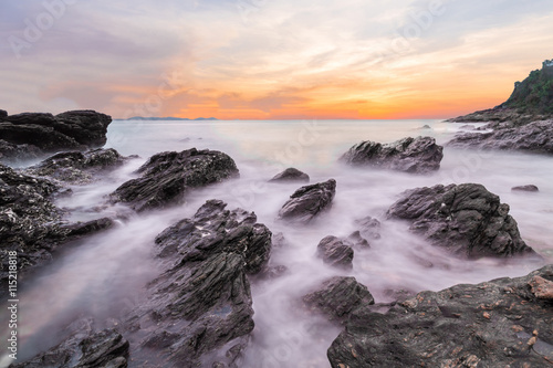 Soft waves of ocean in sunset with stones on the beach foreground at Khao Laem Ya Mu Ko Samet National Park Rayong, Thailand. Seascape long exposure shot
