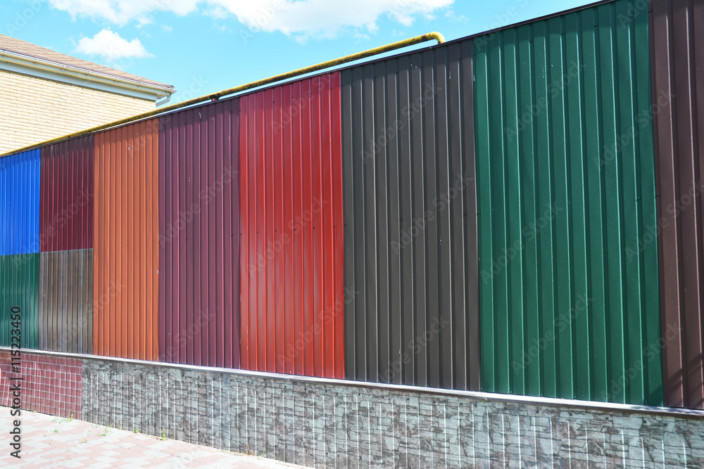 Stacks of various colorful metal fence panels and metal roof sheets for sale. Building and construction materials, colored steel roof tiles for sale. Stacks of various colorful metal fence panels and metal roof sheets for sale. Building and construction materials, colored steel roof tiles for sale.