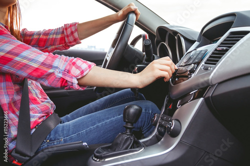 Car dashboard. Radio closeup. Woman sets up radio