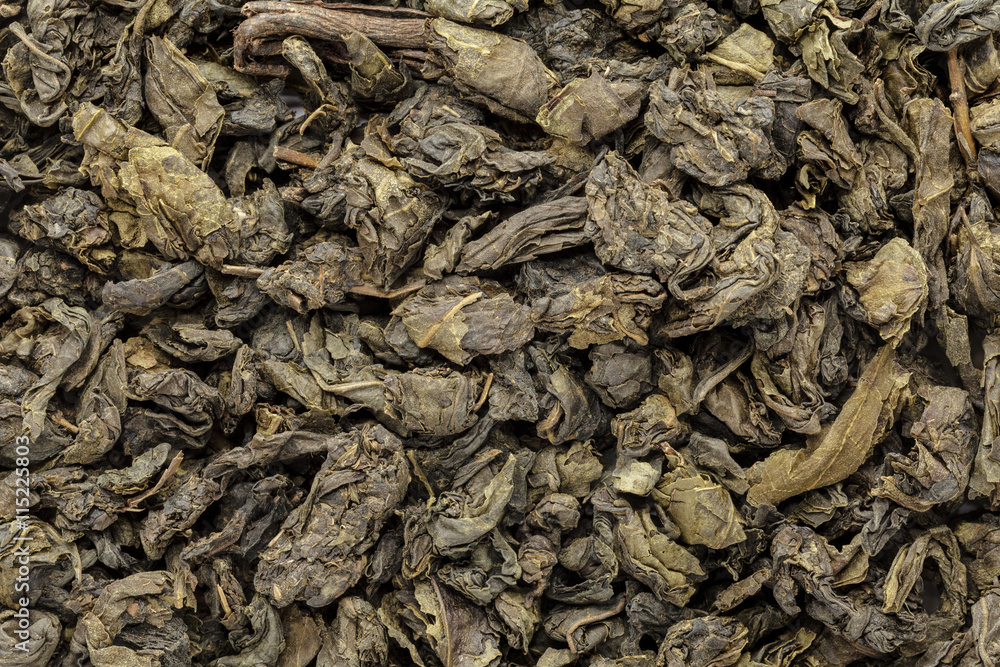 Organic Green Tea (Camellia sinensis) dried whole leaves. Macro close up background texture. Top view.