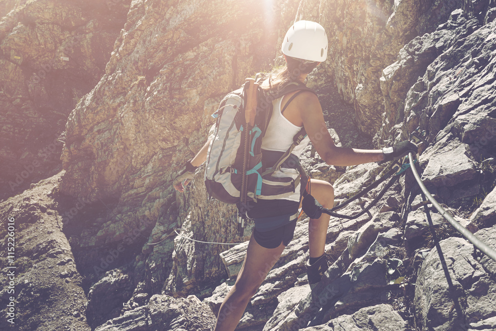 Obraz premium Lone hiker turning to look toward rocks in sun