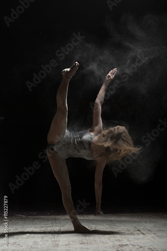 Fototapeta Naklejka Na Ścianę i Meble -  Woman doing vertical splits and sprinkle flour