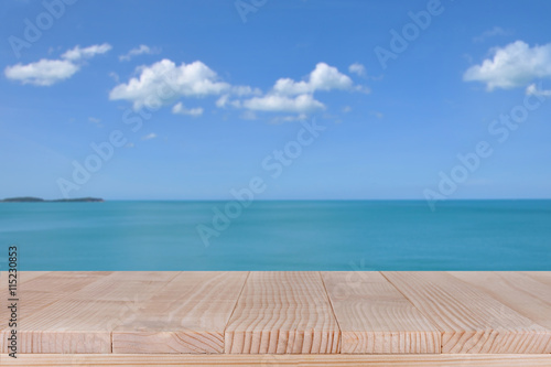 Wood table top on blurred blue sea with cloud background © sripfoto
