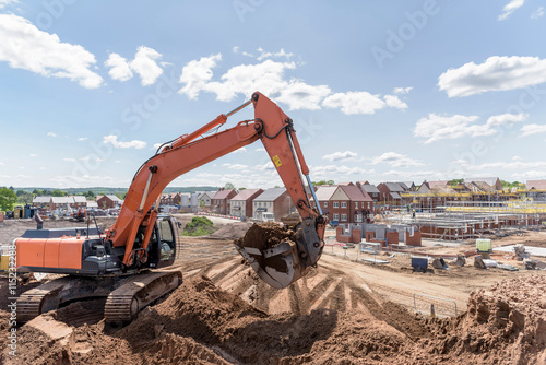 Foto Excavator moving earth on housing building site