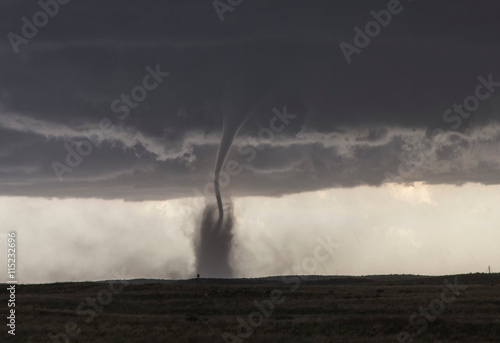  A fine tornado dances within a cloud of dust that moves in ringlets up the lower half of the tornado