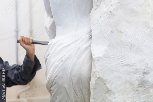 Stonemason using chisel  and mallet to create sculpture
