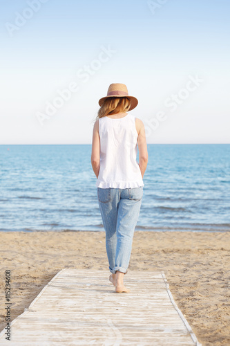 Woman walking on the beach © sepy