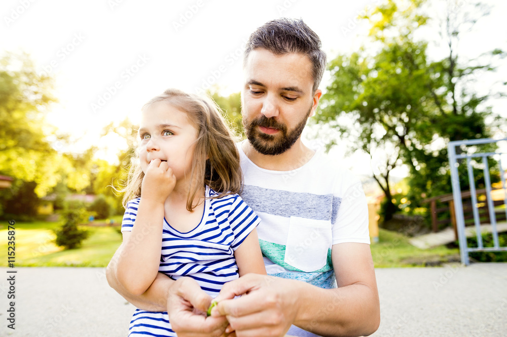 Father and his little daughter together in a park Father and his little daughter together in a park