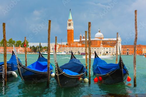 Gondolas moored by Saint Mark square with San Giorgio di Maggiore church in the background in Venice lagoon after the storm, Italia