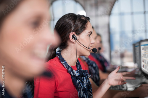 Row of female telephonists working in call centre photo