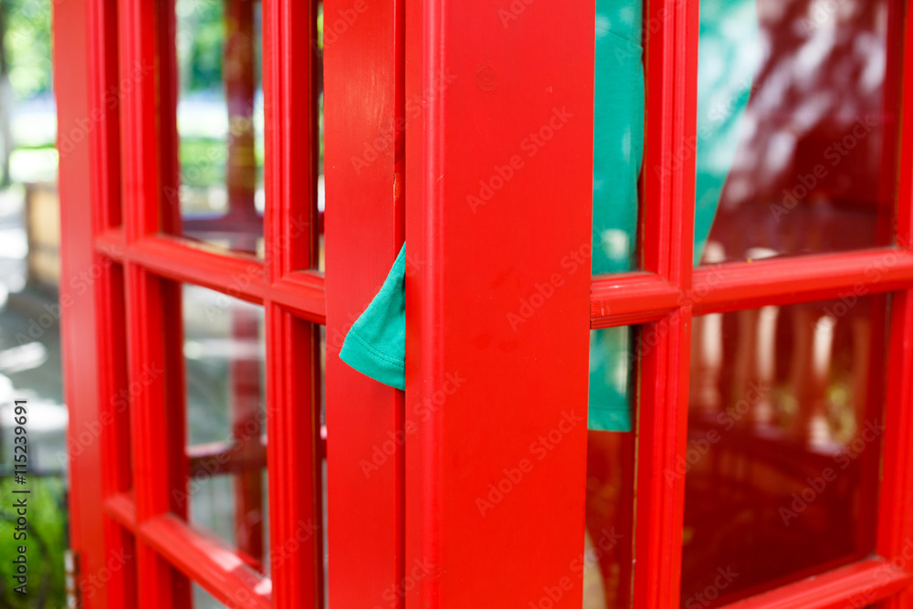 dress clamped door of red telephone box. she quickly hopped into a phone box, was in a hurry to call. dress clamped door red telephone booth. communication concept dress clamped door of red telephone box. she quickly hopped into a phone box, was in a hurry to call. dress clamped door red telephone booth. communication concept