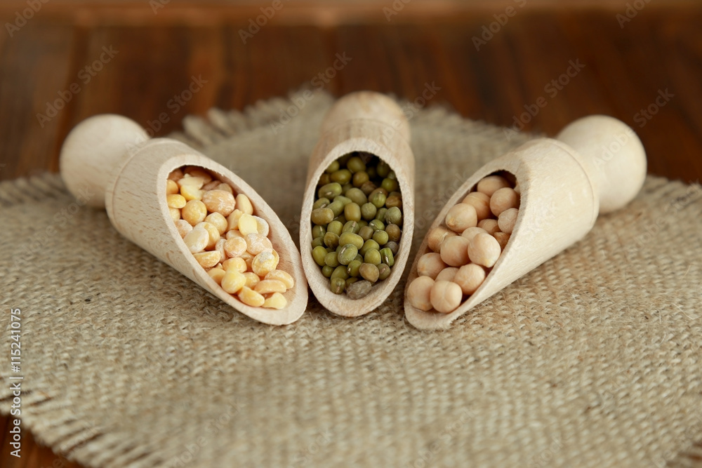 Different legumes in wooden scoops