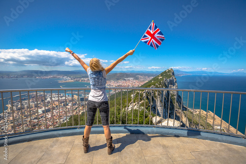 Woman enjoy with the British flag in hand on top of Gibraltar Rock. Gibraltar is a territory of South West Europe Which is part of the United Kingdom.