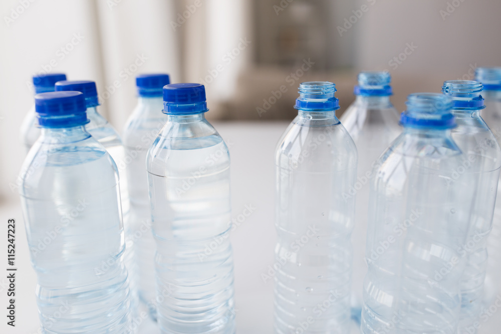 close up of bottles with drinking water on table close up of bottles with drinking water on table