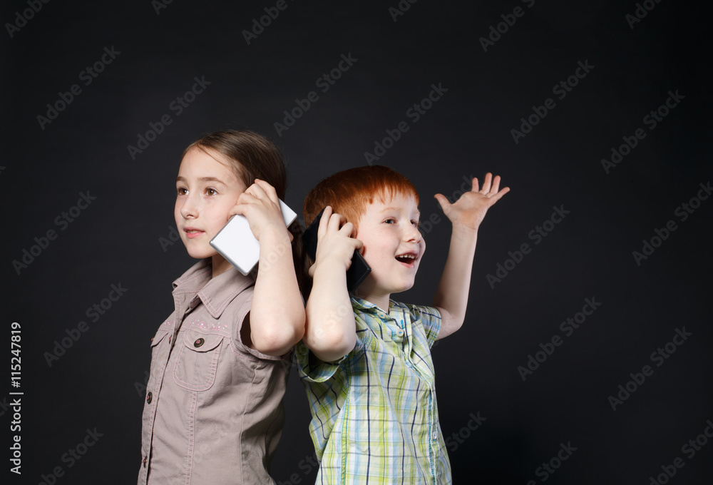 Happy girl and boy, children speak on mobile phones Happy girl and boy, children speak on mobile phones