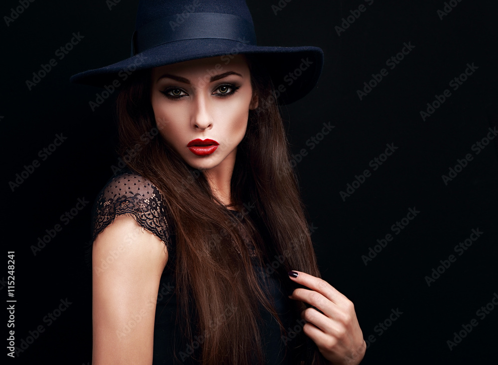 Mysterious makeup woman in fashion hat looking expressive on bla Mysterious makeup woman in fashion hat looking expressive on bla