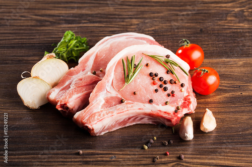 fresh raw pork loin with bay leaf on wooden board photo