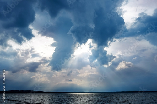 Storm clouds and sunbeams under lake