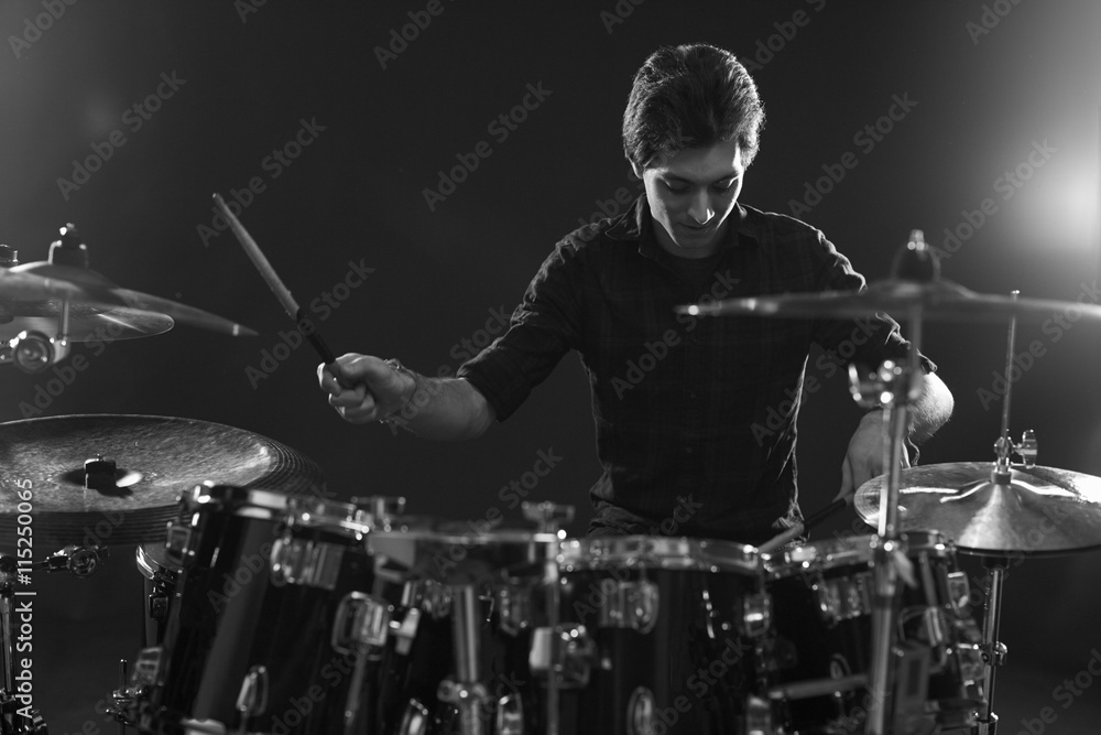 Fototapeta premium Black And White Shot Of Drummer Playing Drum Kit In Studio