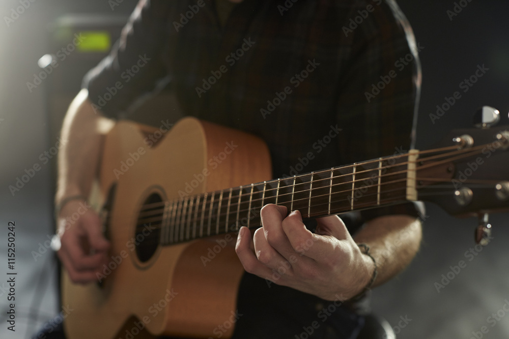 Fototapeta premium Close Up Of Man Playing Acoustic Guitar In Studio